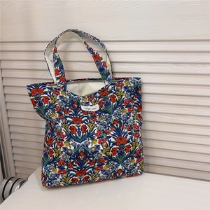 Detailed macro view of retro floral cotton tote bag with vintage flower prints and handles
