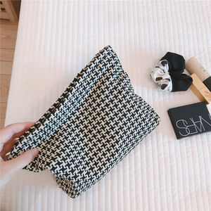 Close-up of black and white houndstooth jacquard fabric texture on the cosmetic bag