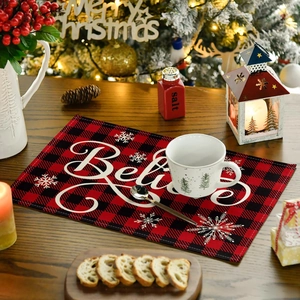 Close-up of red and black buffalo plaid Christmas placemat with white Believe lettering