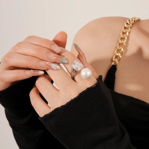 Detail of an open ring featuring a large faceted crystal and a lustrous white pearl