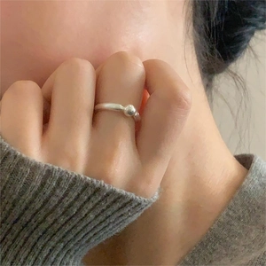 Minimalist silver bead ring shown on finger with a sleek polished finish