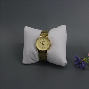 Detail view of a gold-tone quartz watch on a white display pillow with date function