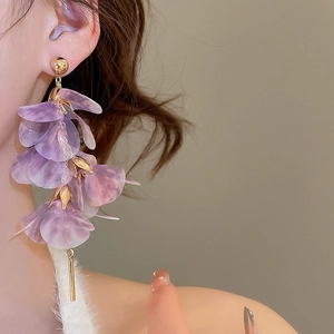 Close-up of elegant purple mesh flower earrings with gold bar tassel on a model