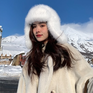 Close-up of white faux fur trapper hat with thick plush texture and ear flaps for winter