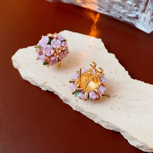 Nahaufnahme der rosa Blumen-Ohrstecker mit Goldbasis und bernsteinfarbenen Kristallen