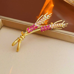 Detailed view of gold-plated wheat brooch with pink and white cubic zirconia crystals