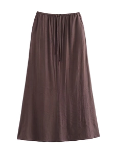 Détail de la jupe mi-longue plissée marron foncé avec taille haute élastique