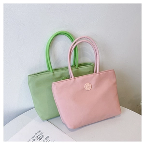 Détail de sacs bandoulière en nylon minimalistes vert et rose avec boucle lettre m