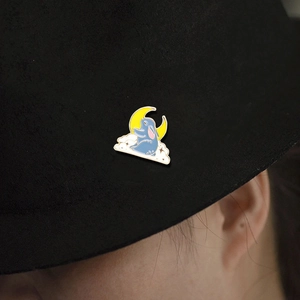 Enamel brooch with blue rabbit on a white cloud and crescent moon on a black felt hat