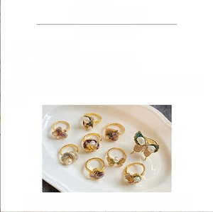 Detailed view of 18K gold plated rings with drip glaze enamel and freshwater pearls