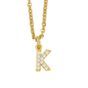 Detailed view of golden letter K pendant with sparkling white zircons on a fine chain