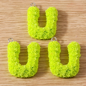 Close-up of green resin U-shaped charms with rose floral texture for DIY jewelry making