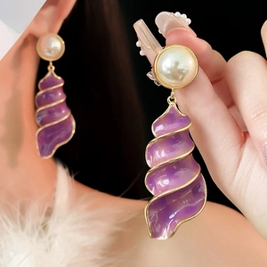 Macro shot of vintage purple enamel spiral earrings with gold trim and pearl studs