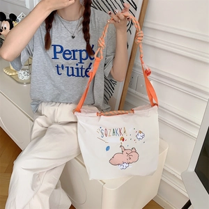 Detail of the elephant embroidery on a canvas tote bag with orange woven shoulder straps