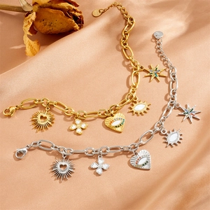 Gold and silver evil eye charm bracelets with heart pendants on silk fabric