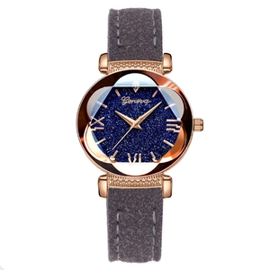Detalle del reloj con esfera estrellada y correa de gamuza gris con caja de oro rosa