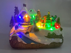 Vue détaillée d'une maison de village de Noël avec LED colorées et décor de neige