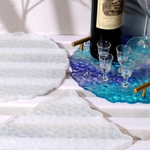 Detailed view of DIY resin trays with gold handles and irregular textured silicone molds