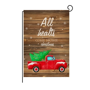 Detail of Christmas garden flag with vintage red truck and tree on linen fabric