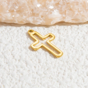 Detailed macro view of a golden hollow cross pendant on a textured rock surface