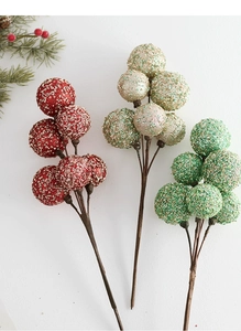 Close-up of glittered Christmas berry stems in red and gold for festive floral decor