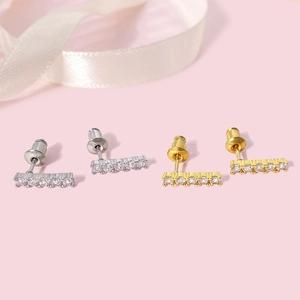 Detailed view of small rectangular stud earrings in gold and silver finish with zircons