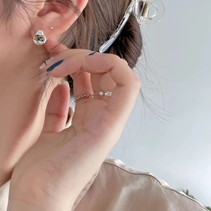 Irregular silver molten studs and twisted rope ring worn for a minimalist aesthetic
