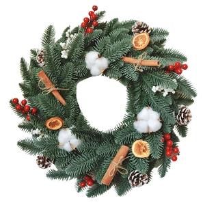 Christmas wreath with green pine needles, red berries, cotton, and cinnamon on white background