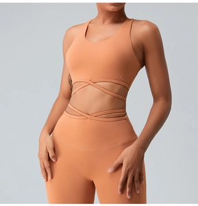 Detailed view of peach yoga sports bra with cross straps and high-waisted leggings