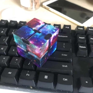Detailed view of the Galaxy Infinity Cube fidget toy resting on a computer keyboard