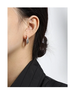 Detailed close-up of multilayer twisted S925 silver hoop earring worn by a model