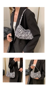 Détail du sac sous le bras à motif zèbre avec fermeture éclair dorée et bandoulière