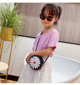 Detail of round black children purse with large daisy flower and thin shoulder strap