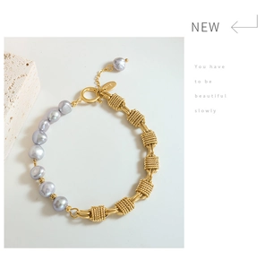 Detail of brass chain bracelet with gray freshwater pearls and gold toggle clasp