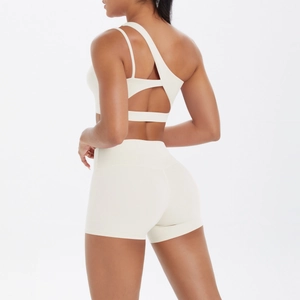 Detail of cream-colored one-shoulder yoga set with asymmetrical cut-out back design