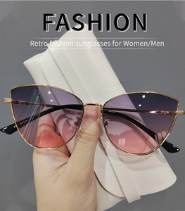 Detail of metal cat eye sunglasses with purple to pink gradient lenses and gold frame