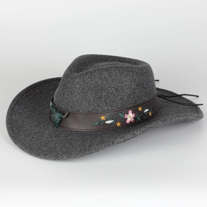 Detail of dark grey fedora hat with embroidered floral leather band and bronze bull head charm