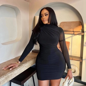 Elegant black bodycon dress with mesh long sleeves and high neck in a warm indoor setting