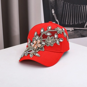 Rote Baseballkappe mit goldener Blumenstickerei und funkelnden Strasssteinen auf Weiß