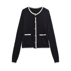Detailed view of cable knit pattern and contrast trim on black cardigan jacket