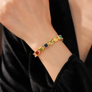 Vue détaillée d'un bracelet vintage doré avec des pierres de zircon carrées colorées au poignet