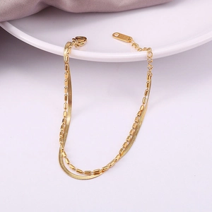 Detail of 18K gold double-layer snake chain bracelet showing K18 hallmark and lobster clasp