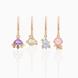 Detailed close-up of space-themed earrings featuring UFO, Saturn, rocket and astronaut charms