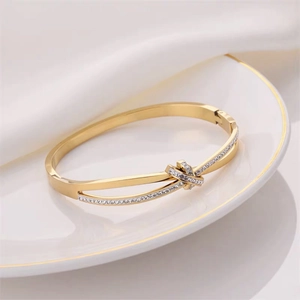 Elegant rose gold knot bangle with sparkling rhinestones on polished stainless steel