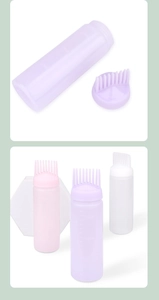 Detail view of pink purple and white hair dye bottles with scale marks and comb nozzles