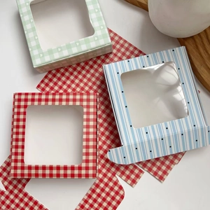 Detail view of paper gift boxes with clear windows in red, green and blue patterns