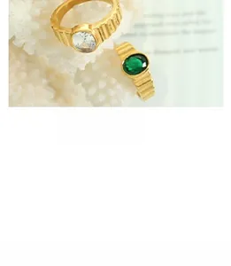 Detailed macro view of two gold ribbed rings with emerald and zircon stones