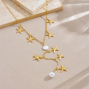 Y-shaped gold starfish necklace with pearls and irregular chains on a neutral background