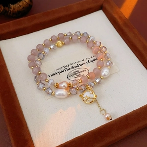 Détail du bracelet double couche en perles œil de chat avec pendentif planète dorée