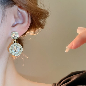 French vintage gold earrings with faux pearls and square crystals on a female model